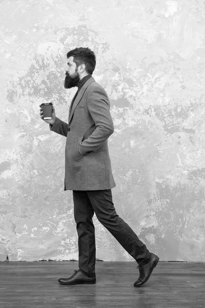 Brutaler bärtiger Hipster in Jeans. Trendiger Mann mit Bart. modernes Leben. Modell für Männermode. Geschäftsleute trinken Kaffee zum Mitnehmen. Casual Style. Neubelebung seiner Energie, um mehr zu arbeiten — Stockfoto