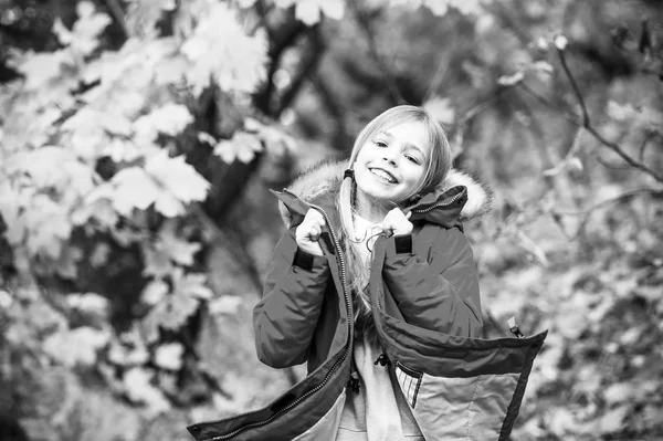 Siéntete tan cómodo con una chaqueta cálida. Chica feliz en abrigo disfrutar de otoño parque natural. Los niños usan abrigo de moda con capucha. Ropa de otoño y concepto de moda. Niño rubio pelo largo caminando en chaqueta caliente al aire libre — Foto de Stock