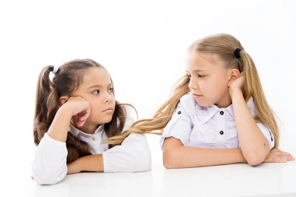 Adorabili studentesse. Torniamo a scuola. Concetto educativo. Belle ragazze migliori amiche. Stile formale. Buona infanzia. Le studentesse siedono alla scrivania sfondo bianco. Studentesse amici emotivi — Foto Stock