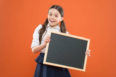 School news concept. Check out responsibilities of pupils. Topic of todays lesson. School schedule information. Informing kids changes in school life. School girl pupil hold blackboard copy space clipart
