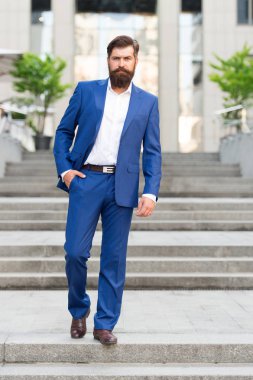İş başarılarına doğru. İş dünyasını fethetmek. Ofis çalışanı kendinden emin bir şekilde merdivenlere basar. Sakallı adam işe gidiyor. Modern şehirdeki iş adamı. İş gününün başlangıcı. Başarı için motive