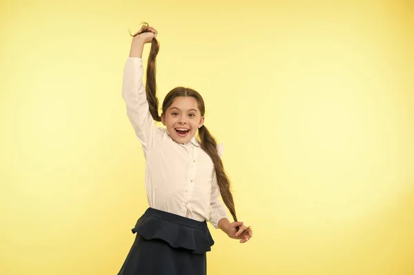 Άνετο και εύκολο χτένισμα. Ασχοληθεί με χτένισμα μακριά μαλλιά με τον εαυτό σας. Παιδί κορίτσι μακριά αλογοουρά χτένισμα. Παιδί σχολείο στολή κάνει κόμμωση. Παιδί μοντέρνο μόδας θέτοντας Κρατήστε αλογοουρές χτένισμα — Φωτογραφία Αρχείου