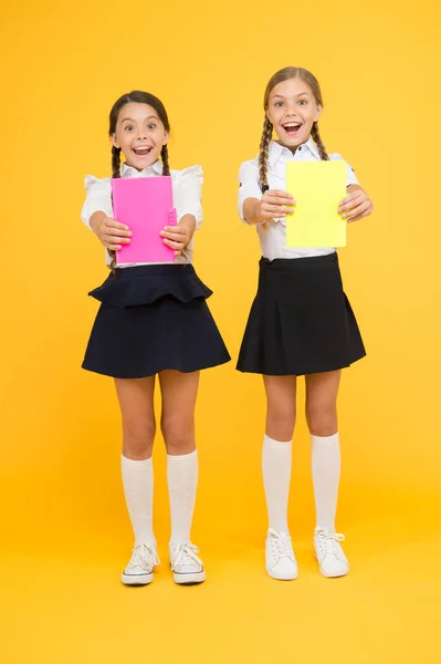 Children with school diaries for notes. Cute schoolgirls holding lesson books. School children learn reading books. Back to school. Little girls with workbooks for writing. Studying in small groups — Stock Photo, Image