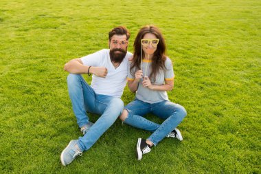 Çift aşık neşeli gençlik standı sahne. Duygusal insanlar. Yaz eğlencesi. Çift randevuları. Tasasız çift eğlenceli yeşil çim sahip. Adam sakallı hipster ve güzel kadın neşeli yüzleri. Gençlik günü