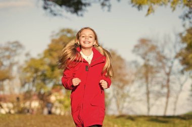 Kendi tarzında. Çocuk kız giyim ceket sonbahar sezonu doğa arka plan için. Vücut sıcak giysiler sonbahar gün tutun. Sonbahar kıyafeti kavramı. Çocuk sonbahar yürüyüşüne neşeli. Sonbahar için sıcak palto en iyi seçim