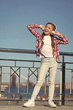 Bırak müzik konuşsun. Küçük kız dışarıda müzik dinler. Mutlu küçük kız. Mutlu çocuk kulaklık takıyor. Küçük müzik hayranı. Sadece mutlu ol.