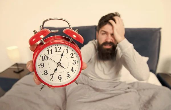 Tips for becoming an early riser. Man bearded hipster sleepy face in bed with alarm clock. Problem with early morning awakening. Get up with alarm clock. Overslept again. Tips for waking up early — Stock Photo, Image