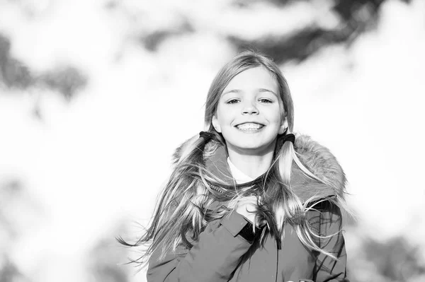 À la mode. La gamine porte un manteau pour l'automne. Enfant marche joyeuse portant un manteau lumineux chaud ou une veste automne journée ensoleillée. Fille sourire visage coiffure mignonne manteau d'automne à la mode avec capuche et fourrure — Photo