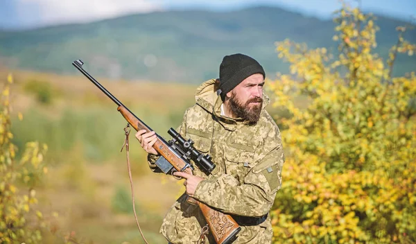 Cazador de rifle. Cazador barbudo pasar tiempo libre de caza. Enfoque y concentración del cazador experimentado. Regulación de la caza. Caza concepto de pasatiempo masculino. Hombre brutal guardabosques naturaleza fondo — Foto de Stock