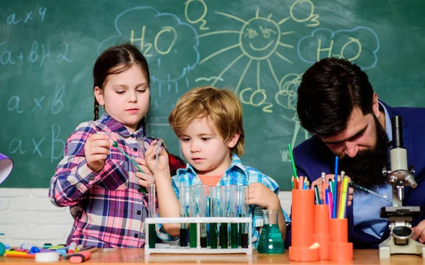 students doing science experiments with microscope in lab. school kids scientist studying science. happy children teacher. back to school. Little kids learning chemistry in school laboratory