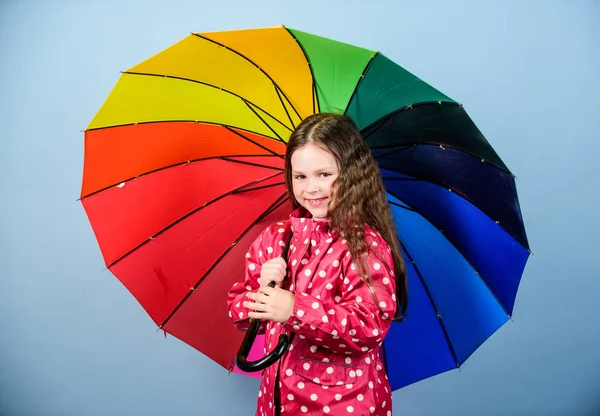 Po dešti se vždycky poduhy. Užijte si to v dešti. Sezóna na podzim. Děvčátko šťastné drží barevný duhový deštník. Deštivé počasí s řádným odětím. Deštivá denní zábava. Šťastná procházka pod deštníkem — Stock fotografie
