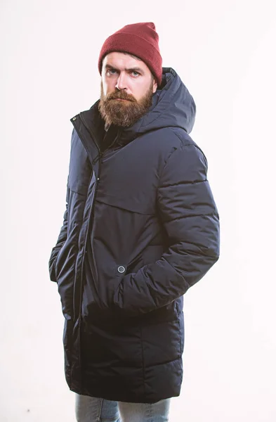 Hipster stil herrkläder. Hipster outfit. Mannen skäggig hipster poserar tryggt i varm svart jacka eller parka. Snygg och bekväm. Hipster modern mode. Killen bär hatt och svart vinterjacka — Stockfoto