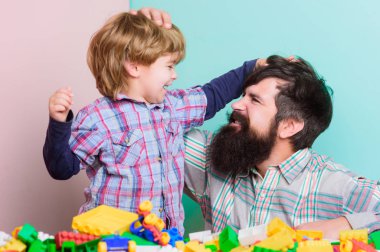 Sakallı hipster ve çocuk birlikte oynarlar. Baba ve çocuk plastik bloklar inşa. Mutlu çocukluk. Çocuk bakım konsepti. Mutlu bir aile. Baba ve oğul tuğlalarla eğlenirler. Çocuk gelişimi ve yetiştirilmesi