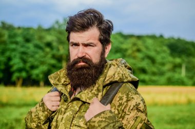 Yürüyüş ve seyahat. Hafta sonu eğlence ve tatil. Yürüyüşçü sakallı adam yürüyüş. Yürüyüşçü maceralar için hazır. Adam sakallı backpacker kamuflaj ceket doğa arka plan giymek. Yürüyüşçü turist. Acımasız erkeksi adam