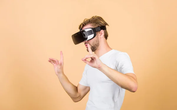 Virtuální simulace. Muž hraje hru ve VR. Vylepšený 3D svět. Prozkoumejte kyberprostor. Na broskvových podkladkách se vtloustne náhlavní souprava. Zábava a vzdělání. Virtuální komunikace — Stock fotografie