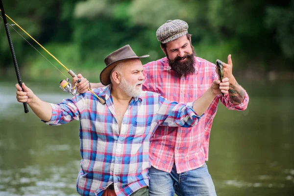 Pesca atividade pacífica. Pescando pai e filho. Avô e amigos maduros. Família dos pescadores. Rod tackle. Equipamento de pesca. Desporto de passatempo. Pesca com carretel giratório. Dia ensolarado de verão no rio — Fotografia de Stock