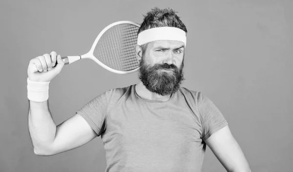 Tennis sport en entertainment. Man bebaarde hipster dragen sport outfit. Concentreer u op het doel. Sport prestatie. Atleet hipster houden tennis racket in de hand rode achtergrond. Tennis speler vintage mode — Stockfoto