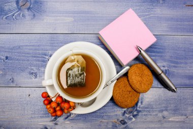 Seramik fincan sıcak taze demlenmiş çay içecek. Sıcak içecek. İçecek aromatik rowanberry içecek. Sağlık hizmetleri halk ilaçları. Mavi arka planda bir fincan çay yakın. Gurme lezzetli tadı. Berry çay