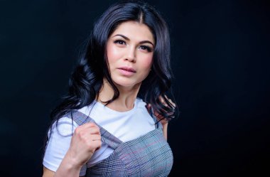 Havalı ve seksi. uzun kıvırcık saçlı kadın. Esmer saçlı güzel bir kadın. makyaj ve kozmetik. kadının cilt bakımı. moda ve güzellik. seksi ve şık olmak. Genç ve güzel