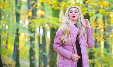 Kız moda sarışın sonbahar parkta yürümek. Sonbahar saç bakım kavramı. Sonbahar saç bakımı böylece Kuru Kıvırcık saç önlemek için önemlidir. Soğuk Sarışın kavramı. Nasıl hızlı ve güvenli bir şekilde ağartılmış saç onarım