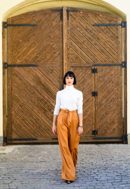 Kadınlık ve kadınsı rakam vurgulamak. Kız makyaj yüz gevşek yüksek bel pantolon giymek. Yüksek belli pantolon moda trendi. Yüksek belli pantolon. Kadın çekici esmer şık giysiler giymek