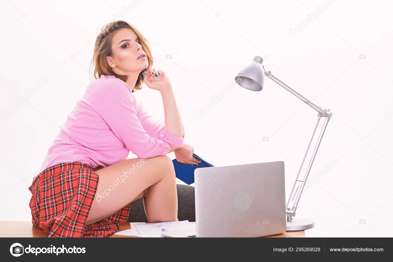 Sexy girl short skirt attractive hips sit on table working laptop. Office manager or secretary. Sexy lady worker. Sexy personal secretary. Sexy girl bored at workplace