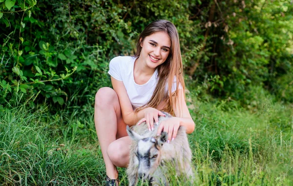 Woman play cute goat. Farm and farming concept. Village animals. Protect animals. Veterinarian occupation. Treating animals at farm. United with nature. Animals law. Girl and goat green grass — Stock Photo, Image