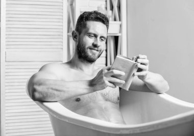 Evde rahatlayın. Tam bir rahatlama. Kişisel hijyen. Sinir sistemi banyo yarar. Rahatla konsepti. Adam kas gövde küvet dinlenmek ve kitap okuyun. Sıcak banyoda dinlenirken rahat adam kitap okuma