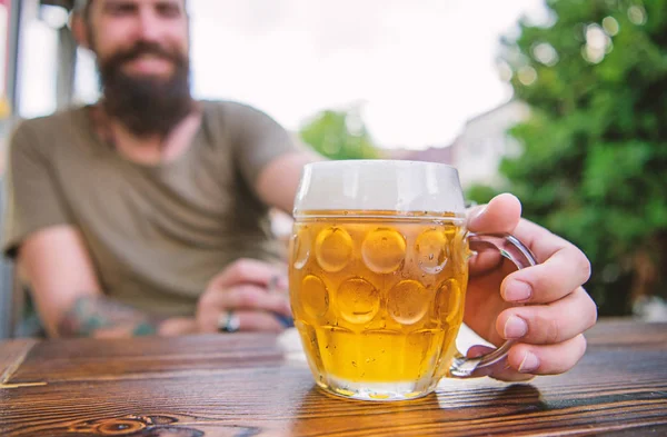 Criativa jovem cervejeira. A cerveja artesanal é jovem, urbana e elegante. Cultura de cerveja distinta. Caneca de cerveja fresca fria na mesa de perto. Homem sentar terraço café desfrutando de cerveja desfocada. Conceito de álcool e bar — Fotografia de Stock