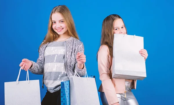 Gyerek divat. Kék háttér. Sisterhood és a család. megtakarításokat vásárol. Kis lányok bevásárló táskák. Eladások és kedvezmények. Boldog gyermekeim. Kislány nővérek. Divatstílus. szépség és divat — Stock Fotó