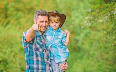 Şirin bir kovboy. Bahçede küçük bir yardımcı. Doğada yaşayan küçük bir çocuk ve baba. Macera ruhu. Babam gibi güçlüyüm. Güç, baba olmaktır. Çocuk eğleniyor kovboy baba. Köylü ailesi.