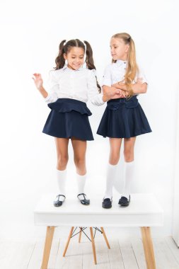 Çocukluk mutluluğu. Okul günü. Çocuklar sevimli okul öğrencileri masada duruyor. Aynı dalgada. En üstte. Sınıftapopüler kızlar. Okul arkadaşlığı. Schoolgirls düzenli görünüm okul üniforması