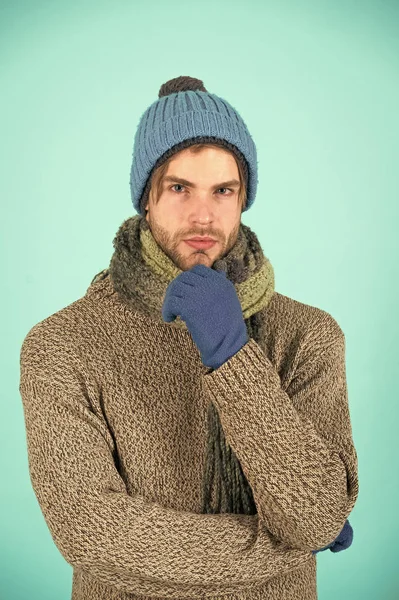 Knitted accessories as hat and scarf. Man in knitted hat and scarf winter fashion season. Man wear knitted clothes turquoise background. Winter accessories concept. Winter fashion knitted clothes