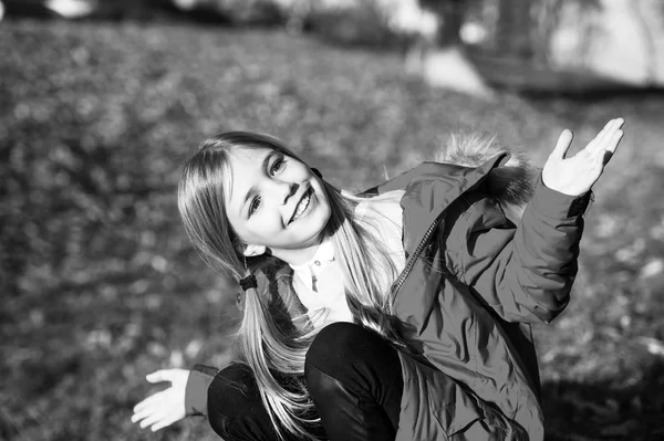 Siéntete feliz día soleado de otoño. Chica chaqueta de desgaste feliz con capucha disfrutar de la naturaleza caída. Los niños usan abrigo para la temporada de otoño. Ropa de otoño y concepto de moda. Niño rubia pelo largo caminando caída parque fondo —  Fotos de Stock