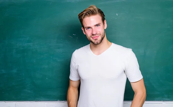 Avantages pour les enseignants primaires masculins sont abondants. Professeur conférencier intéressant. Je retourne à l'école. Enseigner pourrait être plus amusant. Maître de la simplification. Professeur homme devant tableau noir — Photo