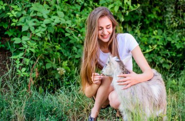 Kız ve keçi yeşil çimenleri. Çiftlik ve tarım kavramı. Köy hayvanları. Hayvanları koruyun. Veteriner mesleği. Çiftlikte ki hayvanları tedavi etmek. Kadın sevimli keçi yi oynuyor. Doğayla birleşmiş. Hayvanlar hukuku