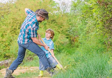 Kürekle hazine arayan küçük bir çocuk ve babası. Mutlu bir çocukluk. Hazineler için macera avcılığı. Bahçedeki küçük yardımcı. Doğadaki şirin çocuk kovboy babasıyla eğleniyor. Hazineleri bul