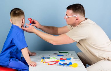 Tıbbi muayene. Hastane çalışanı. Tıbbi hizmet. Adam doktor küçük çocuk hasta muayene masa tıbbi araçları oturup. Sağlık. Çocuk doktoru kavramı. Dikkatli çocuk doktoru çocuğun sağlık kontrol