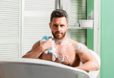 Adam yakışıklı kaslı adam banyoda rahatlatıcı. Cilt bakım konsepti. Sabun lu sudlarla banyo yapıyorum. Sıcak veya sıcak bir banyo ile kendinizi tedavi lüks yüksekliği gibi hissedebilirsiniz. Şımartma ve güzellik rutini