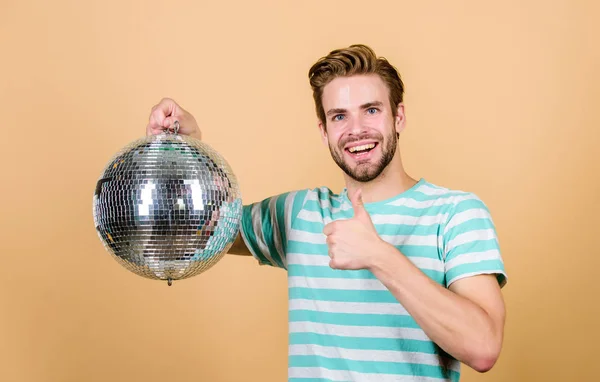 Cheerful dj man. How about party. Handsome man hold disco ball. Disco dances night club. Retro music. Guy inviting you at party. Thousand tiny mirrors reflecting lights creating disco atmosphere