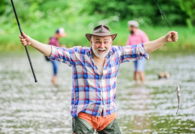 Balık yetiştiriciliği pisciculture ticari olarak balık yetiştirme. Emekli eğlencesi. Kancadaki balıklar. Adam kıdemli balıkçı. Balıkçı balıkçılık ekipmanları. Balıkçı tek başına nehir suyunda duruyor. Hobi spor aktivitesi