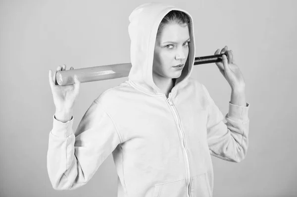 Una mujer juega béisbol o va a vencer a alguien. Mujer en el deporte de béisbol. Concepto de jugador femenino de béisbol. Ella es peligrosa. Chaqueta con capucha chica mantenga el bate de béisbol fondo azul. Brutal y matón — Foto de Stock