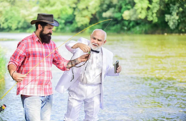 Learn to fish. Fishing skills. Fish with companion who help in emergency. Men friends relaxing river background. Personal instructor. Expert fisherman. Bearded man elegant businessman fish together