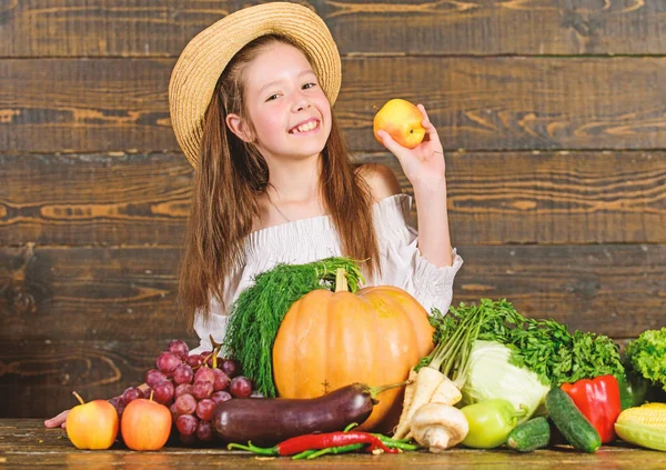 Farm activities for kids. Girl kid farm market with fall harvest. Child celebrate harvesting. Kid farmer with harvest wooden background. Family farm festival concept. Traditional autumnal fest