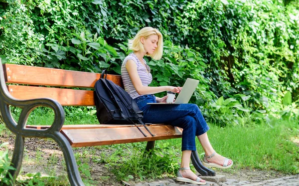 Rendszeres tanuló. Lány imádnivaló diák, laptop és kávéscsésze ülni padon parkban. Tanulmány a szabadban. Nő hallgató dolgozik-val Jegyzetfüzet. Tanulj tanulmányutat. Szörfözés Internet. Modern diákélet — Stock Fotó