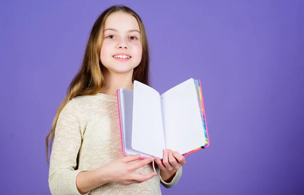 幼年期の文学開発と教育。読書のスキル。個人的な日記メモ帳プランナー。学校の文房具。詳細情報。女の子は本の紫色の背景を保持します。キッドショーブックメモ帳。書籍のコンセプト — ストック写真