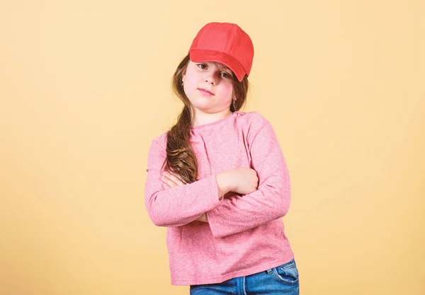 Cutie em boné. Moda moderna. Um acessório elegante. Moda infantil. Sentindo-se confiante com este boné. Menina bonito criança usar boné ou snapback chapéu bege fundo. Menina vestindo boné de beisebol brilhante — Fotografia de Stock