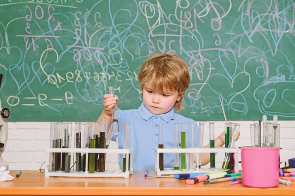 Wunderkind e desenvolvimento inicial. Pequeno aluno aprendendo química na escola. Laboratório de química. Conceito de conhecimento prático. Bolsas de estudo e bolsas de estudo. Crianças inteligentes realizando teste de química — Fotografia de Stock