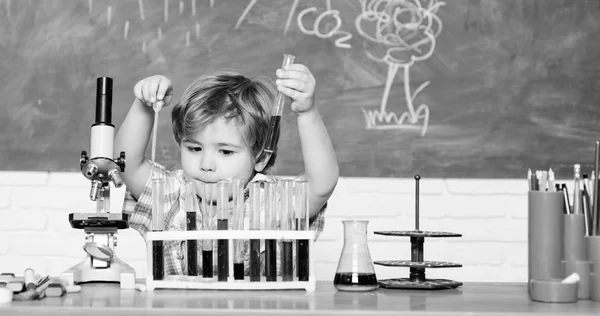 Becas de estudio y becas. Chico realizando la prueba de química. Wunderkind y el desarrollo temprano. Los pequeños alumnos aprenden química en la escuela. Laboratorio de química. Concepto de conocimiento práctico. Descubre líquidos — Foto de Stock