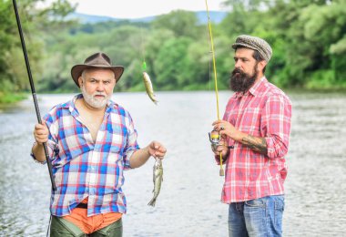 Köklerimize geri dönelim. Gölün kıyısında kamp. Büyük av balıkçılığı. Dostluk. av turizmi. baba ve oğul balık tutuyor. olta ve ağ ile iki mutlu balıkçı. Sinek Balıkçılık Zamanı. Hobi